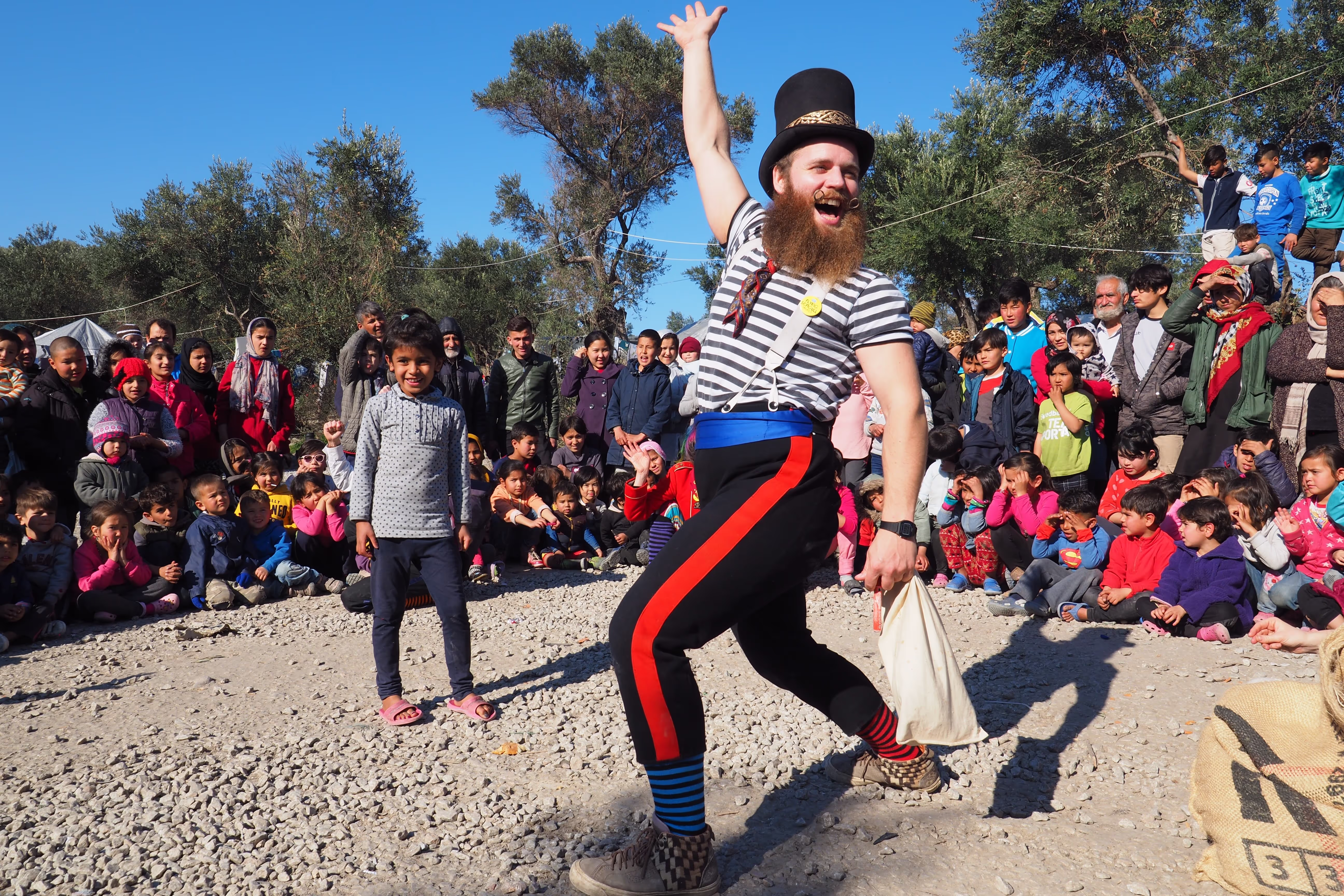 Et bilde fra forestillingen til Flying Seagulls. En skjeggete mann står foran en stor folkemengde.