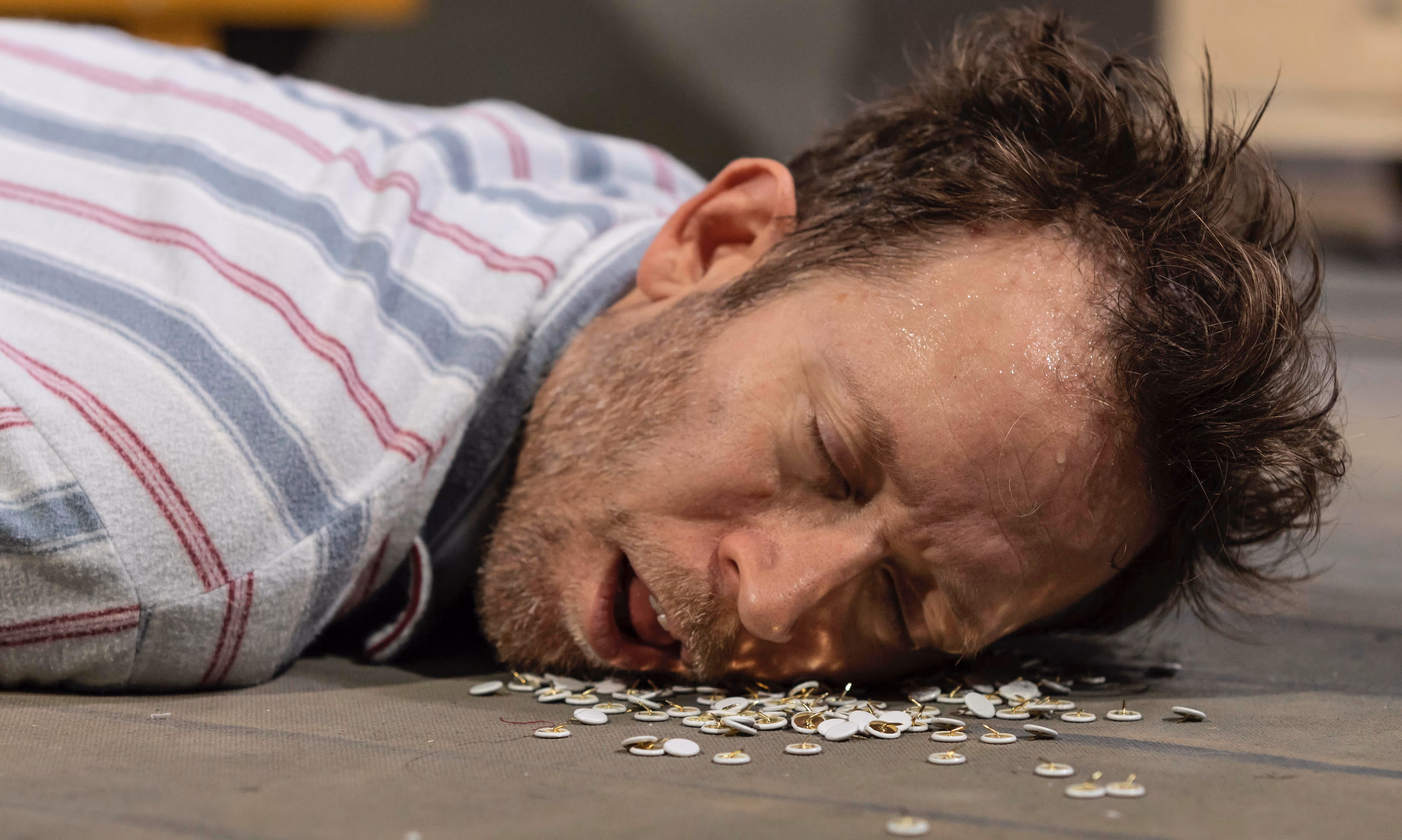 En trøtt og eldre mann sover på masse skarpe ting